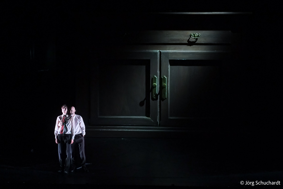 Darkly lit interrogation scene: Porfiry challenges Raskolnikov by monumental furniture at Dramaten